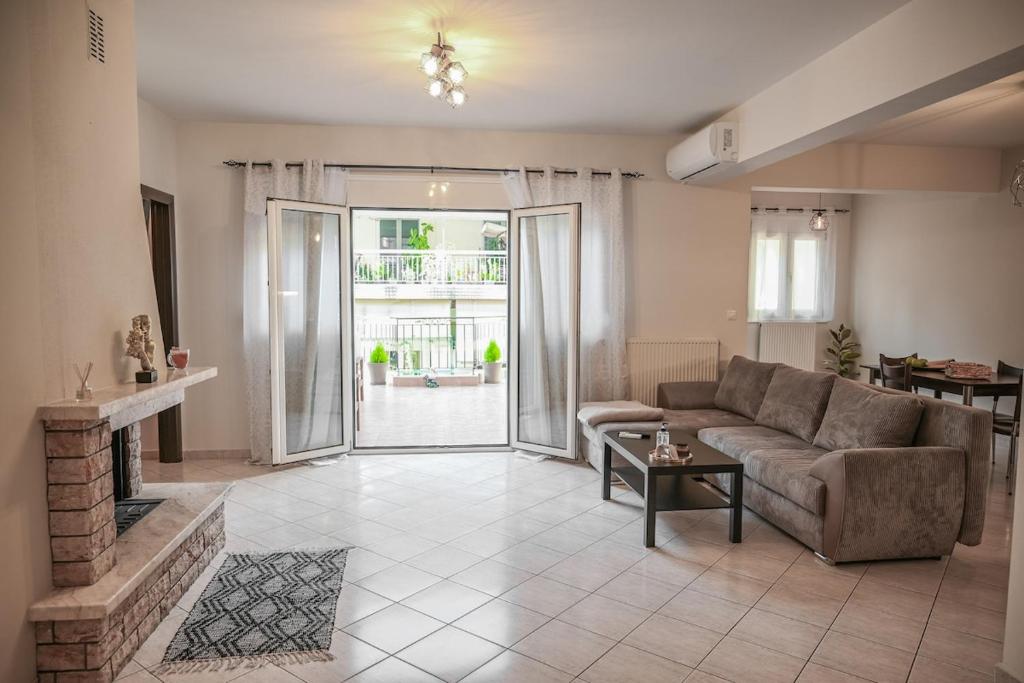 een woonkamer met een bank en een open haard bij Stellina's Spot in Larisa