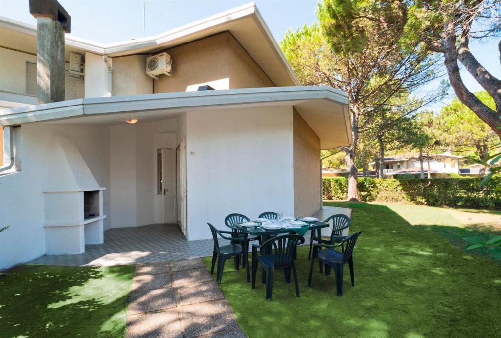 a patio with a table and chairs in a yard at Olimpia in Bibione