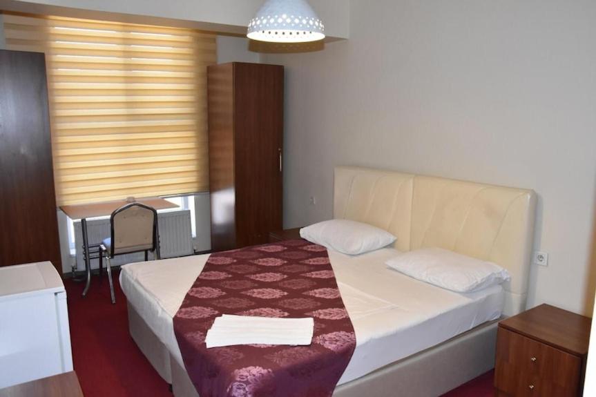 Un dormitorio con una cama y una mesa y una ventana. en Hotel Bulut, en Erzincan