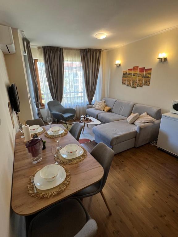 un soggiorno con un tavolo e un divano di Vesta Boutique Apartment a Bansko