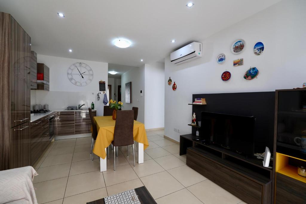 a living room with a dining room table and a kitchen at Central 2 Bed Apartment in Gwardamanġa