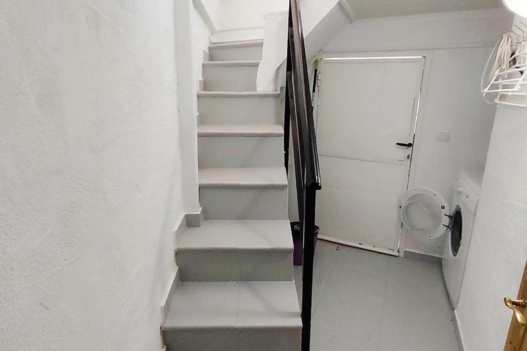 a staircase in a room with white walls and white stairs at Rustige, nette vakantie woning met veel extra's in San Miguel de Salinas