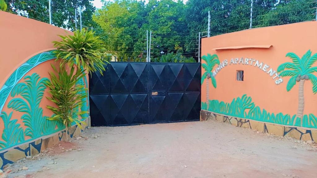 a black gate with a palm tree painted on it at Zion Apartment Diani in Diani Beach
