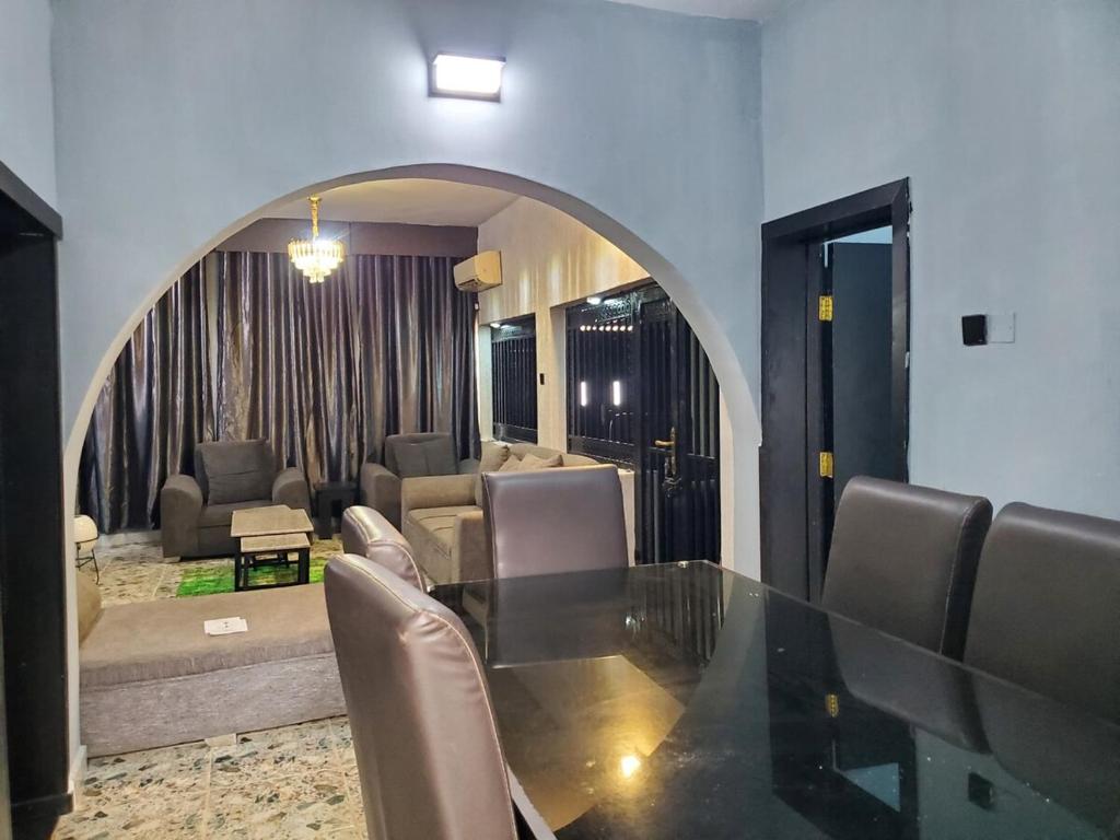a dining room with a glass table and chairs at Villa 29 in Enugu