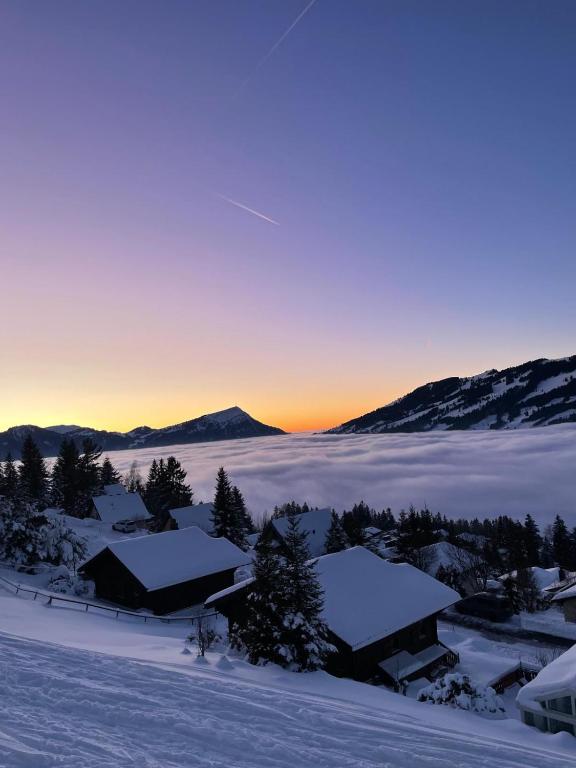 a view of a snow covered village with the sunset at Ferienhaus Mostelrain in Sattel