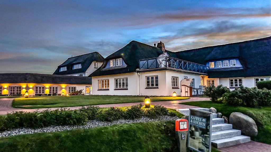 a large white house with a dark roof at Haus Amanda in Norddorf