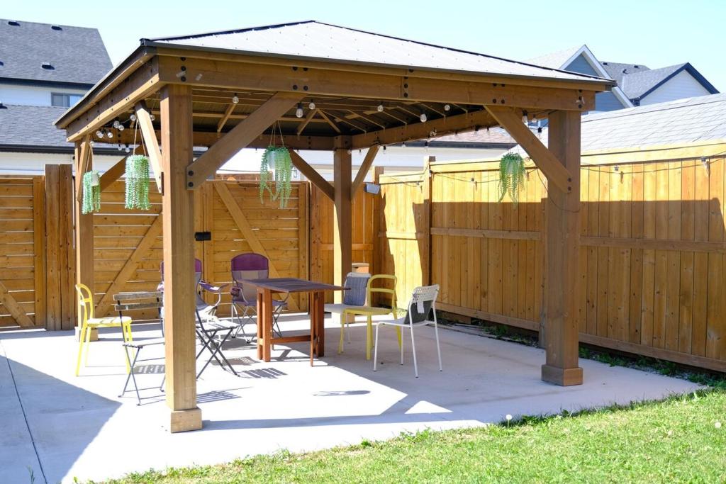 a wooden gazebo with a table and chairs at Mahogany Suite Retreat in Calgary