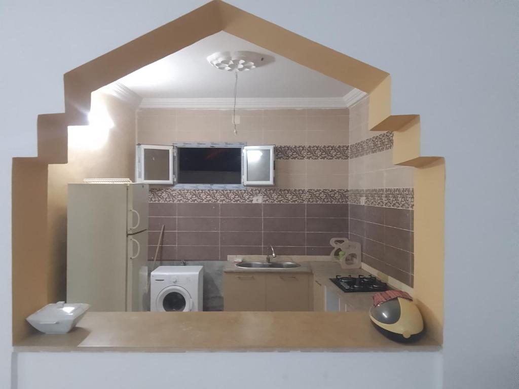 a small kitchen with a sink and a microwave at appartement Tozeur médina in Tozeur