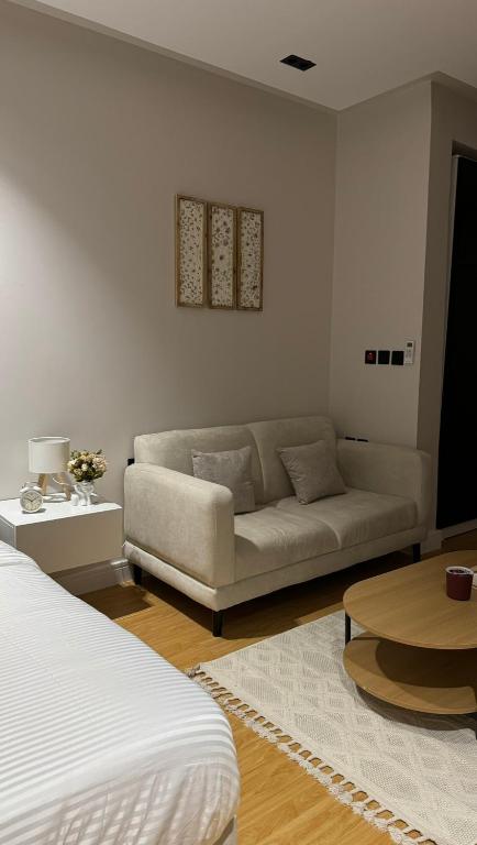 リヤドにあるHotel Studio in Hittinのソファとテーブルのあるリビングルーム