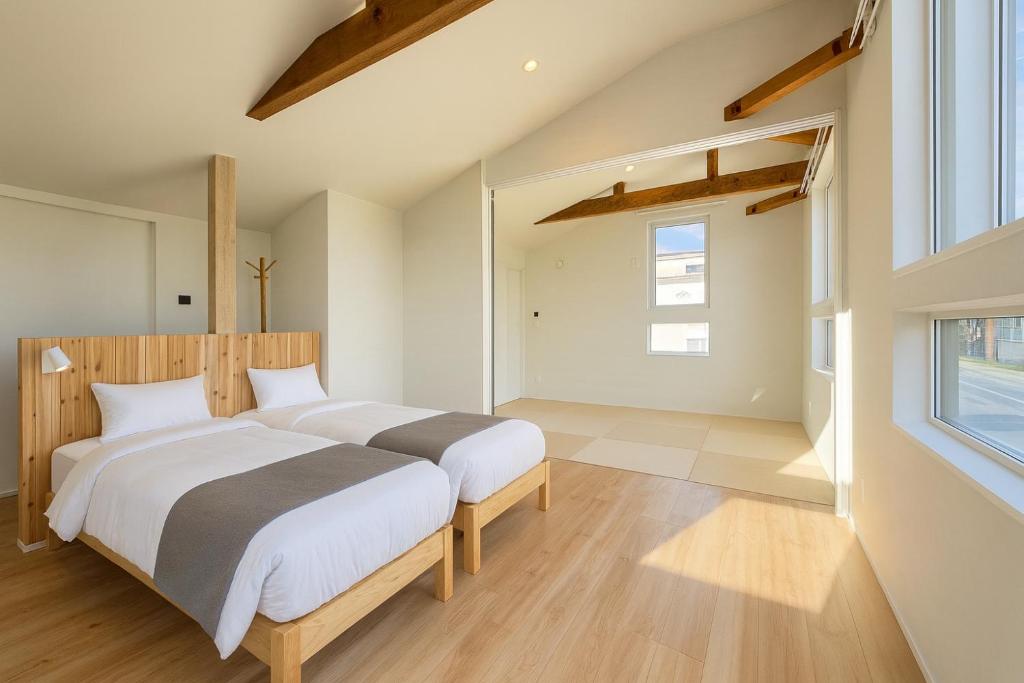 a bedroom with two beds and a window at The Lobs Toya, Chalet Secca in Lake Toya