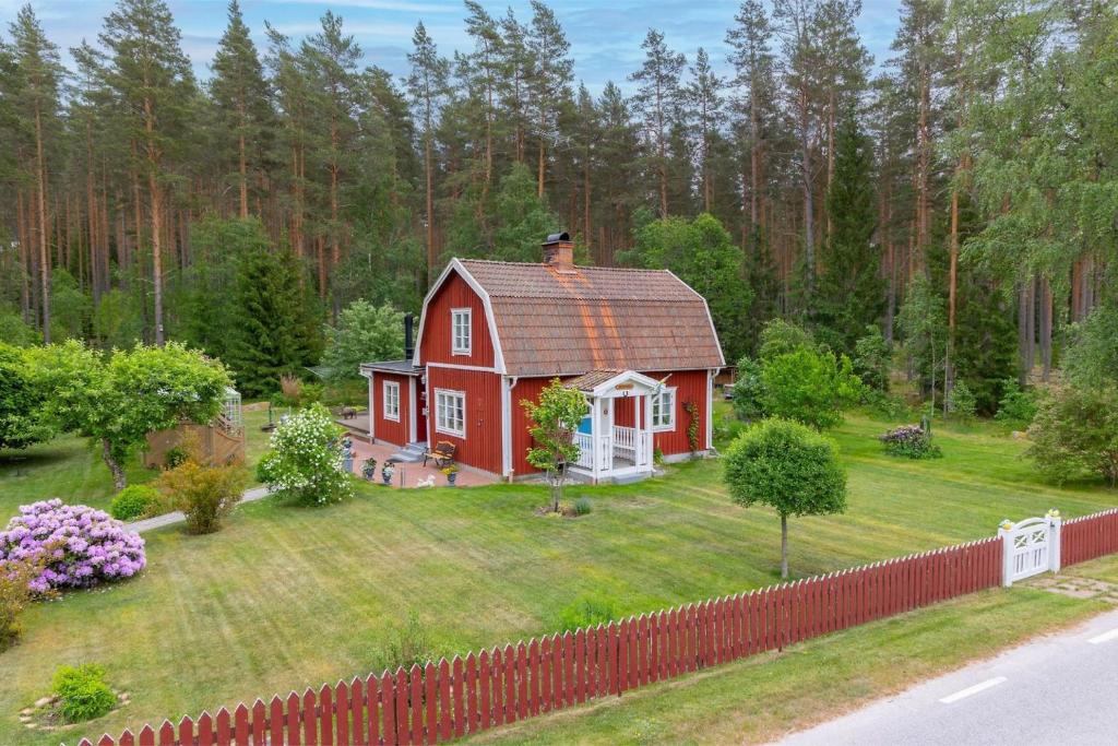 a red house in the middle of a yard at Lindgren Land in Ventzelholm