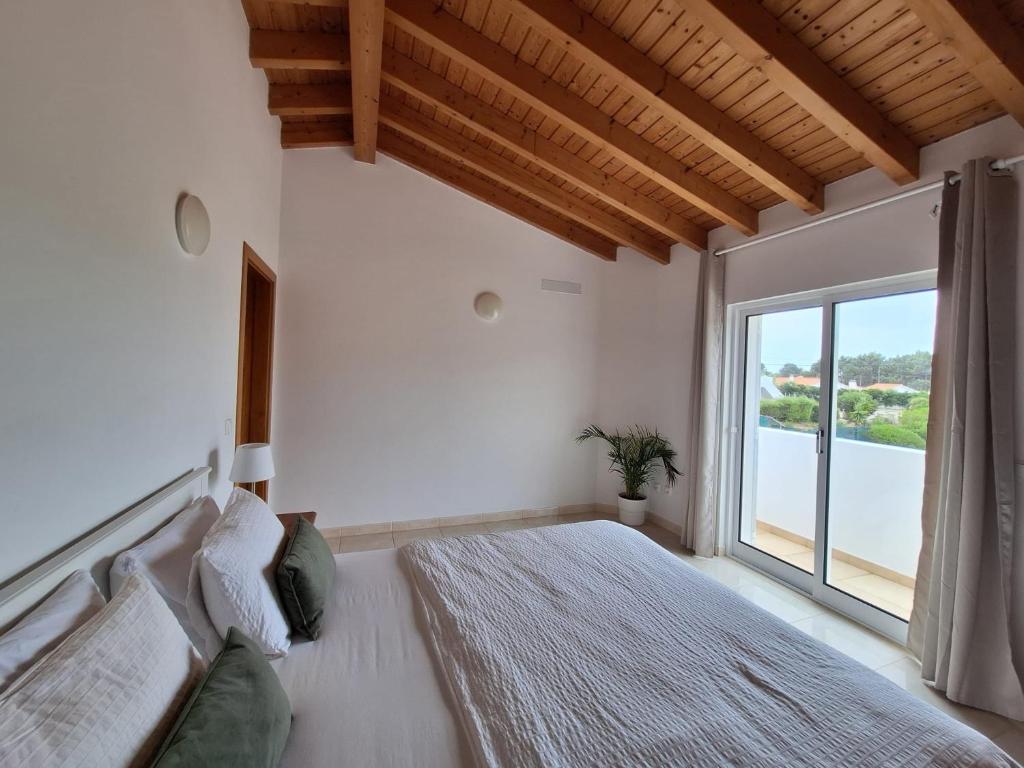 a bedroom with a large bed with a large window at Villa Flavia in Aljezur
