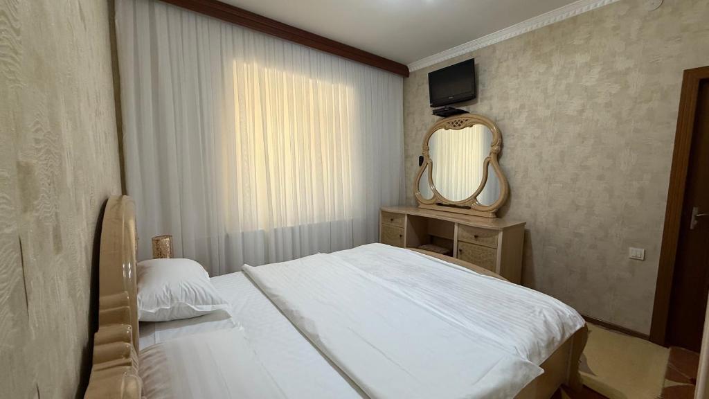 a small bedroom with a bed and a mirror at MOK Apartment in Samarkand