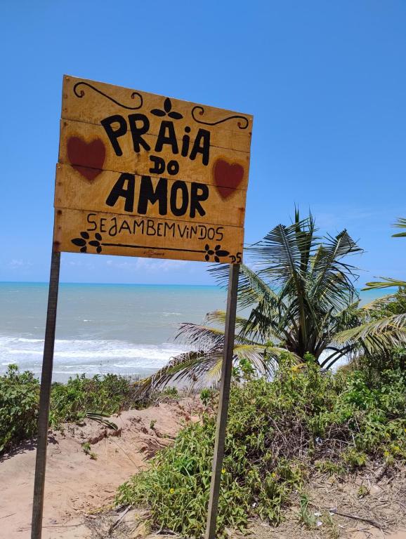 een bord met de tekst 'bid, doe amnor' op een strand bij House 31 Pipa in Pipa