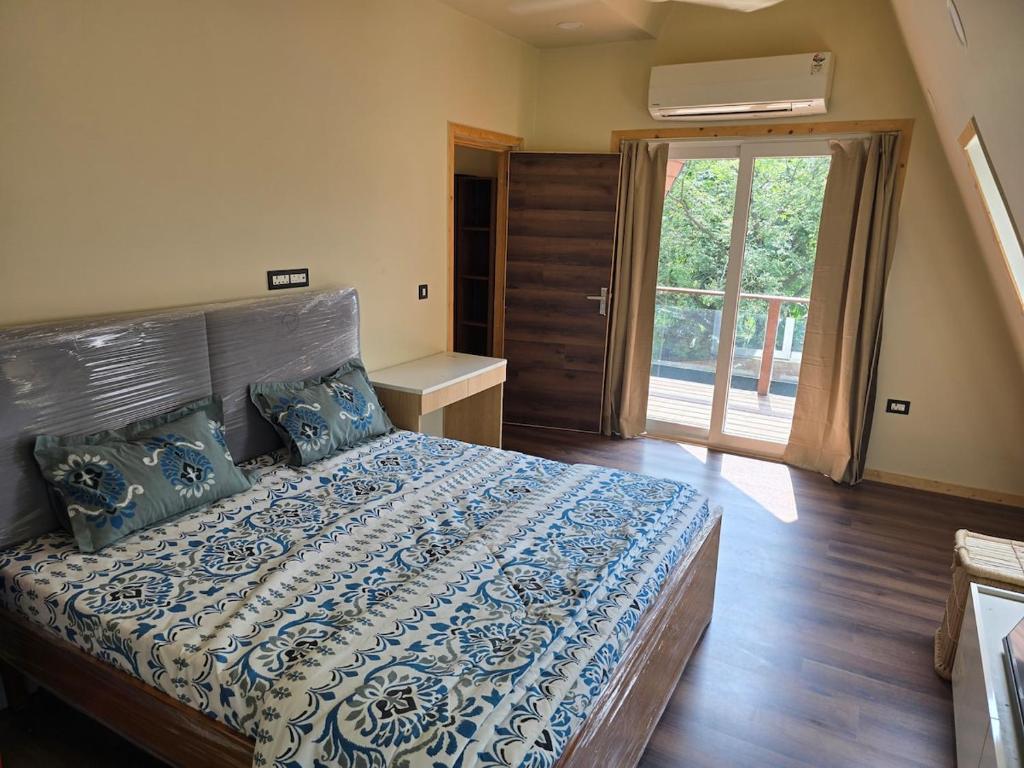 Un dormitorio con una cama con un edredón azul y blanco. en Sky Bloom DLF 2BHK Luxury Villa Chattarpur, en Nueva Delhi