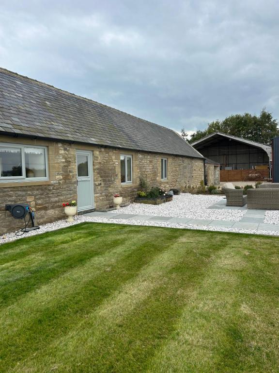 a stone house with a lawn in front of it at High Shilford Barn in Ridingmill