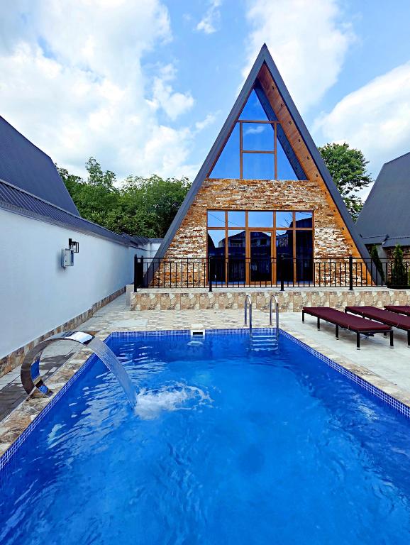 una casa con piscina y una iglesia en солнечный, en Mekhrably