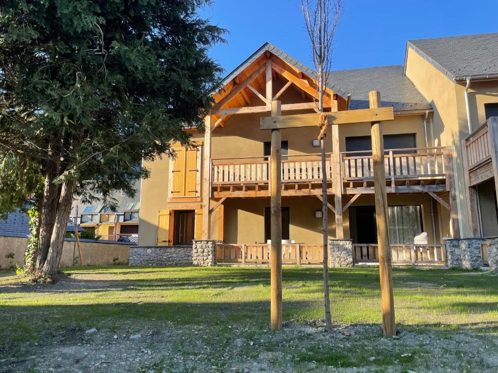 a house with a deck on the front of it at Appartement Résidence Les Lauzes in Vielle-Aure