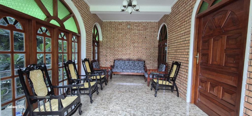 a room with chairs and a table and a brick wall at Shane`s Home Stay in Katugastota
