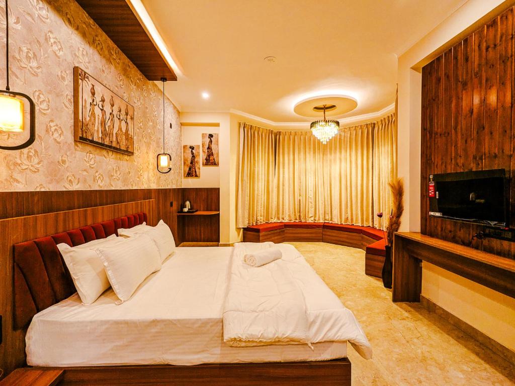 a bedroom with a large bed and a television at Heavenly Retreat, Shangarh in Shangarh