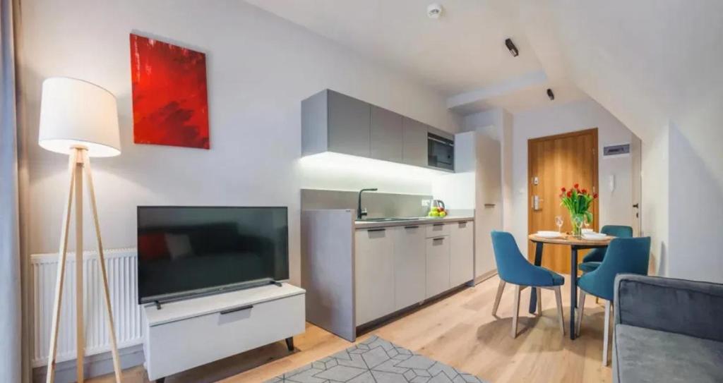 sala de estar con TV y cocina en Apartament Białka Tatrzańska A&M, en Białka Tatrzanska
