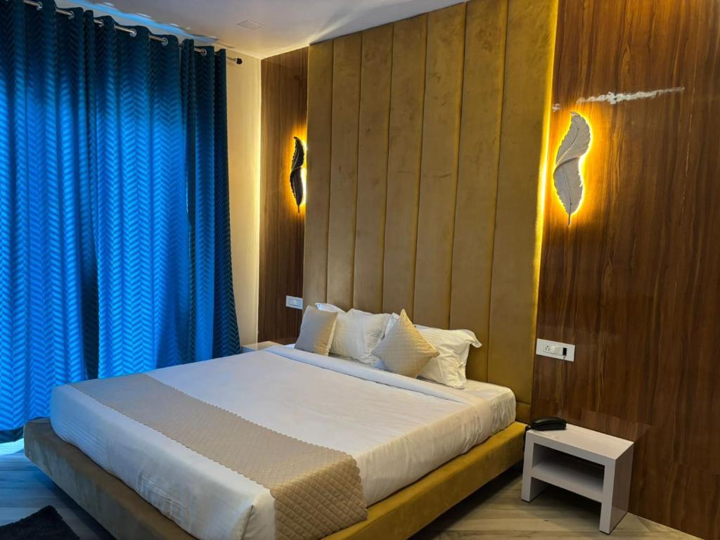 a bedroom with a large bed with blue curtains at The food villa in Gaushala