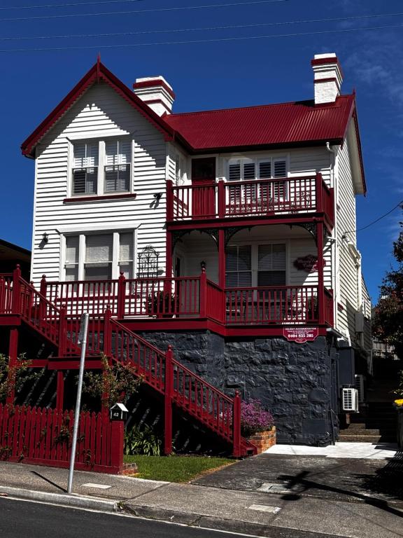 Mersey River Cottage ( cir 1888) Central location with Amazing Ocean and Habour Views. في ديفونبورت: بيت ابيض كبير بسقف احمر