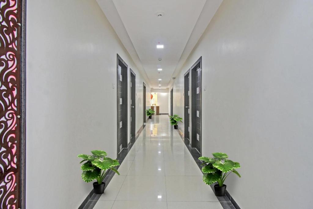 a hallway with potted plants in a building at Hotel O Raj Mahal in Turambhe