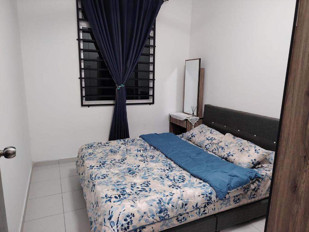 a bedroom with a bed with blue sheets and a window at Khaierah homestay in Kampong Ayer Resam