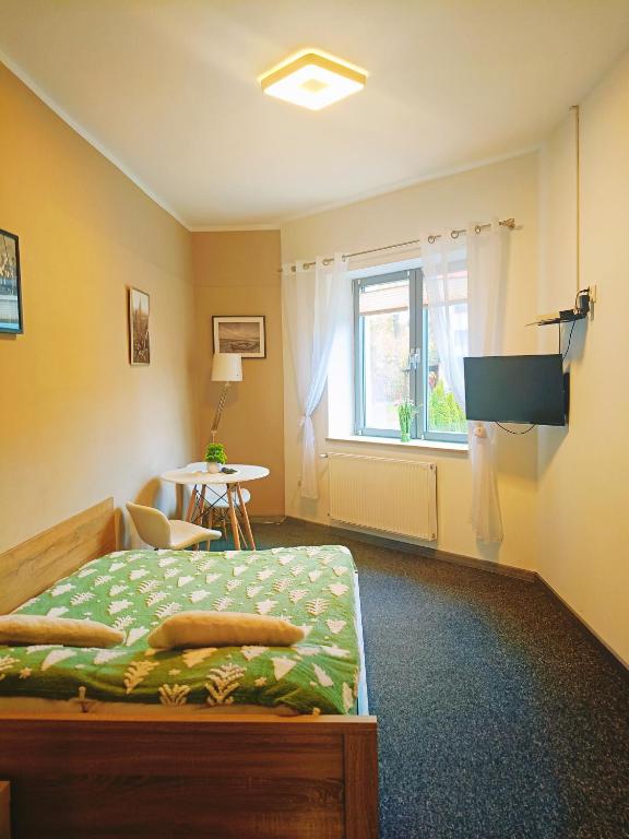 a bedroom with a bed and a window and a table at Apartament Maja in Bielsko-Biała