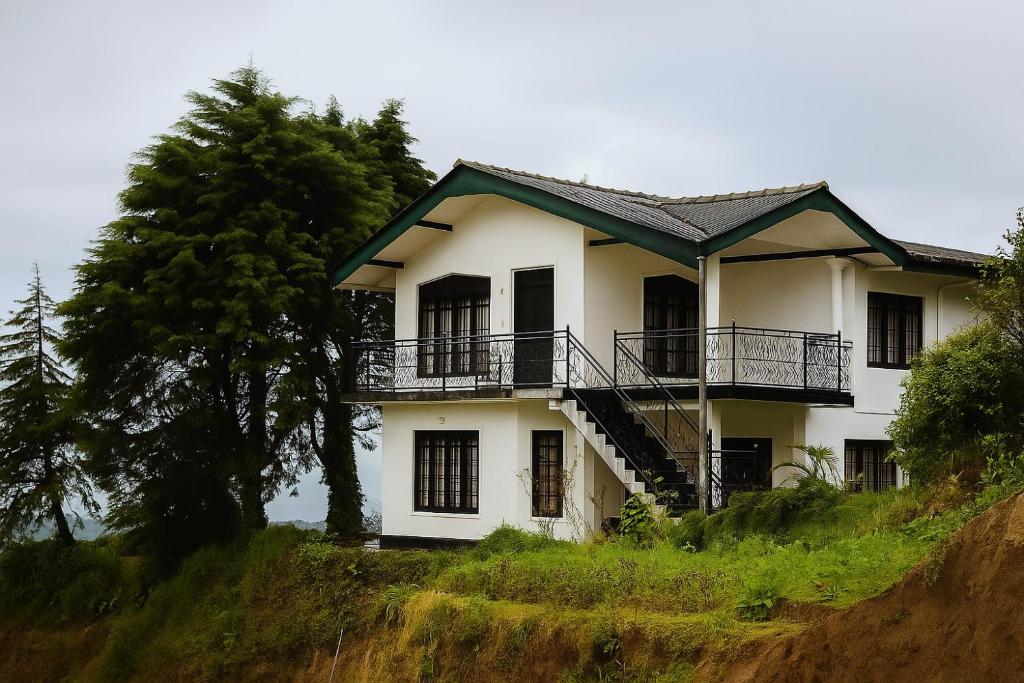 a white house on top of a hill at The Crowns Lodge in Nuwara Eliya