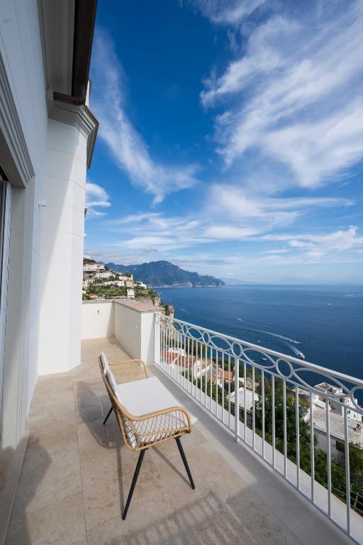 a chair on a balcony with a view of the ocean at Dimora de Feo in Amalfi