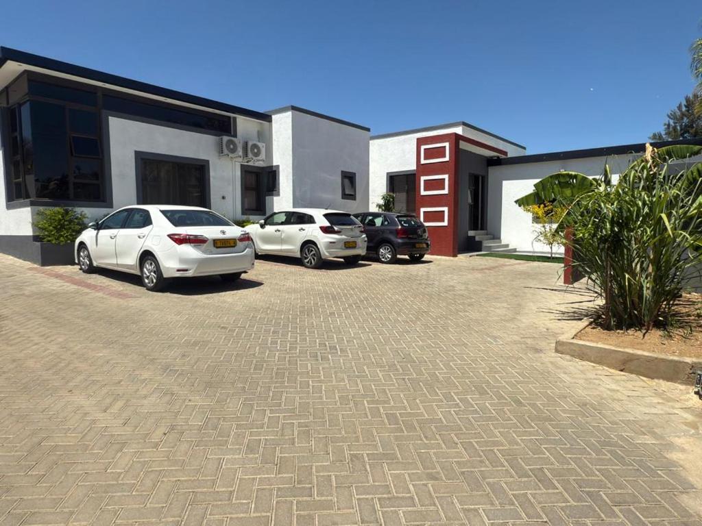three cars parked in a parking lot next to a building at Golden View Boutique Guesthouse in Windhoek