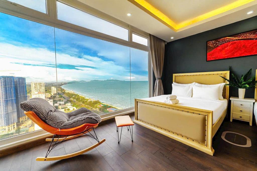 1 dormitorio con cama, silla y ventana grande en Homestay Osaky view biển, en Vung Tau