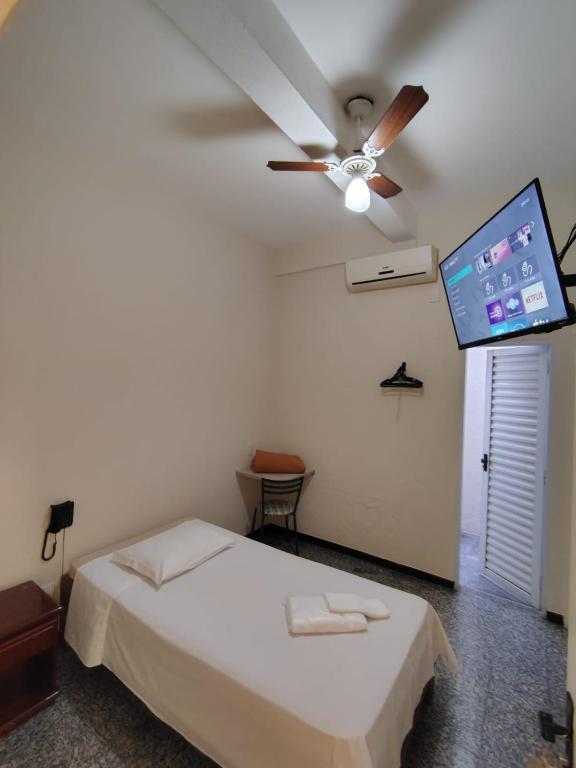 a bedroom with a bed and a ceiling fan at BIGS HOTEL in Penápolis