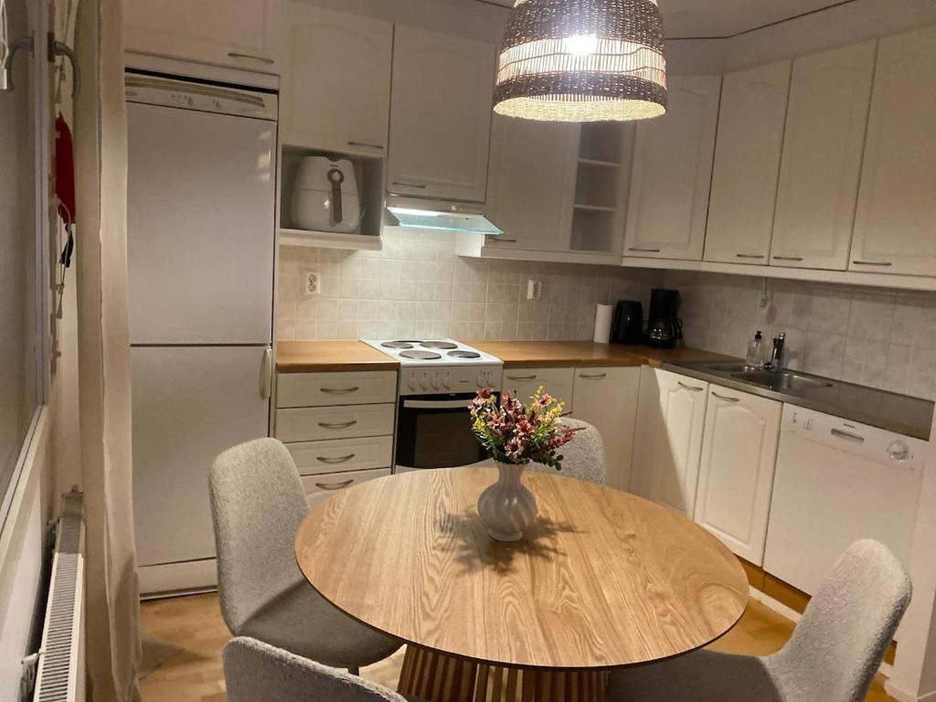 eine Küche mit einem Tisch mit Stühlen und einer Vase mit Blumen in der Unterkunft Valoisa saunallinen luhtitalokaksio Joupista in Seinäjoki