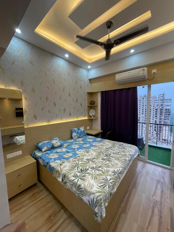 a bedroom with a bed with a ceiling fan at Infinity Haven in Greater Noida