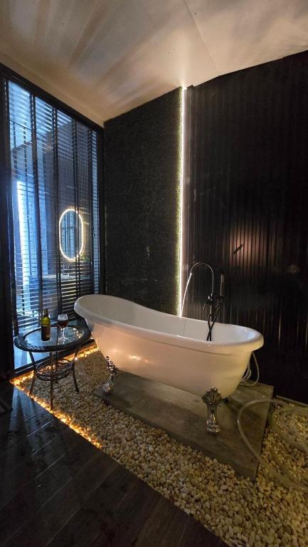 a bathroom with a large white tub in a room at bonheur house betong in Betong