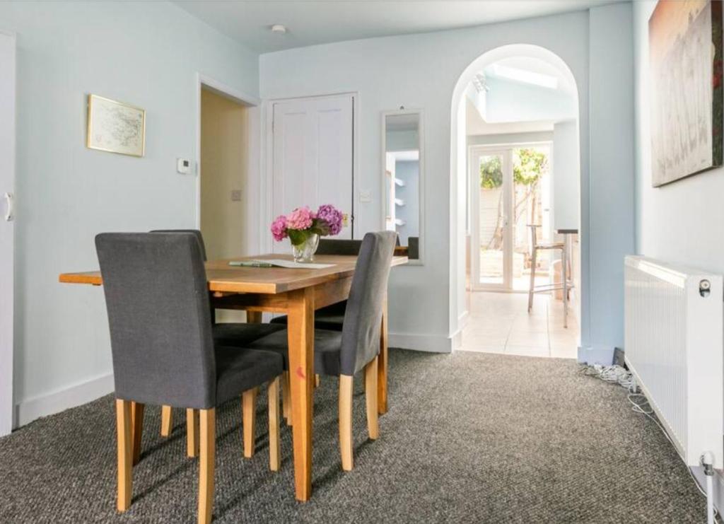 a dining room with a wooden table and chairs at Central Beach Cottage - outside conservation area, minutes walk to all amenities in Deal