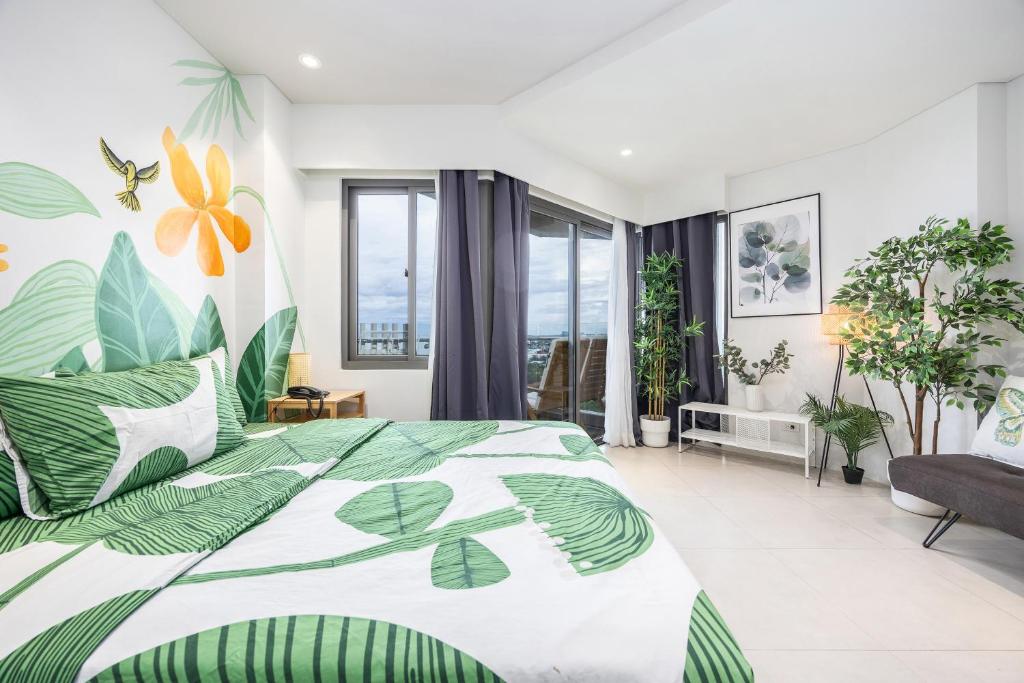 a bedroom with a large bed with green leaves at Jungle Studio at Tambuli Ocean View by Dominik Studio with Pool & Balcony in Mactan in Lapu Lapu City