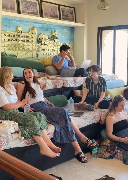 a group of people sitting on beds in a room at Citylights By MUSAFIR in Udaipur