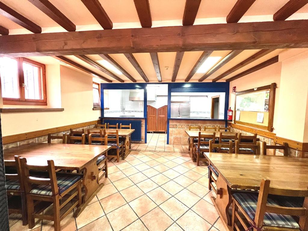 a dining room with wooden tables and chairs at Albergue Urbasa in Eulate
