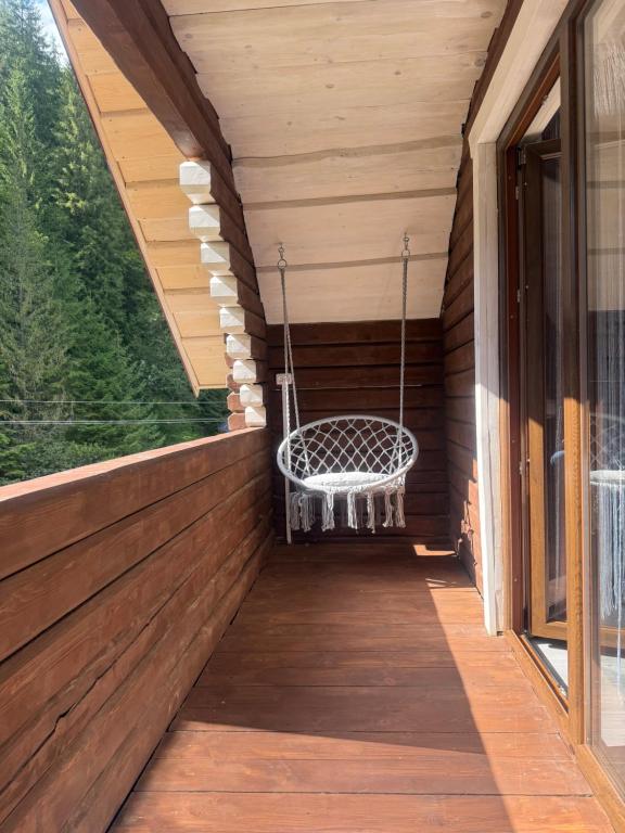 een schommel op de veranda van een huis bij Гірська роса 2 in Synevyrsʼka Polyana