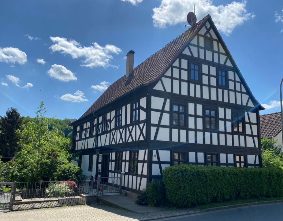 a black and white building with a roof at Fachwerkzauber Eggenbach in Ebensfeld