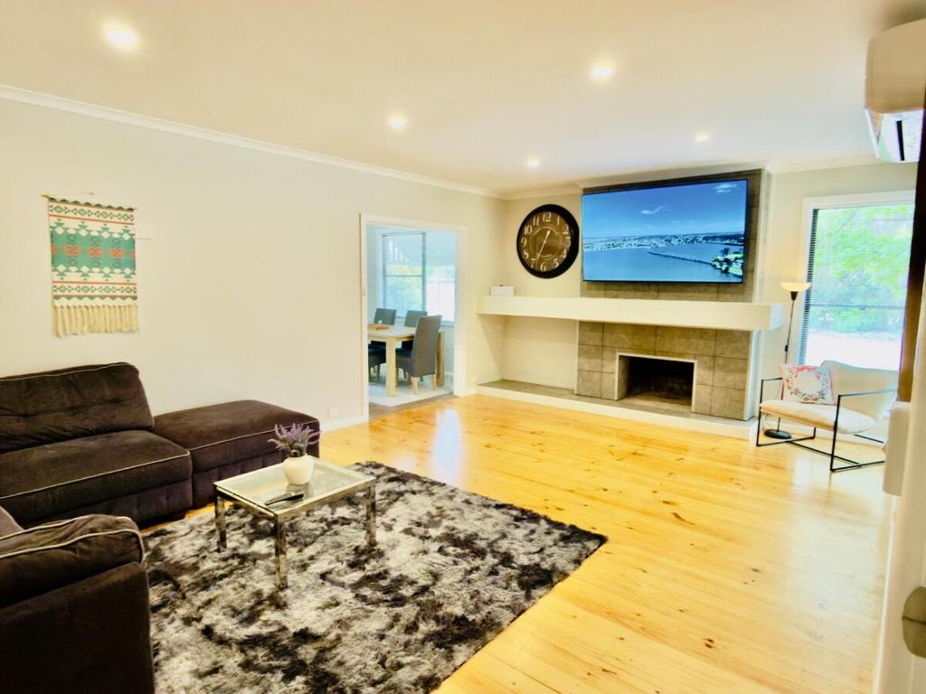 a living room with a couch and a tv and a fireplace at Lakeside Haven - Park the Boat, Relax and Unwind in Mulwala
