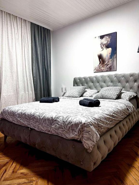 a bedroom with a large bed with a leather headboard at NeNa Apartmani - Ruma in Ruma