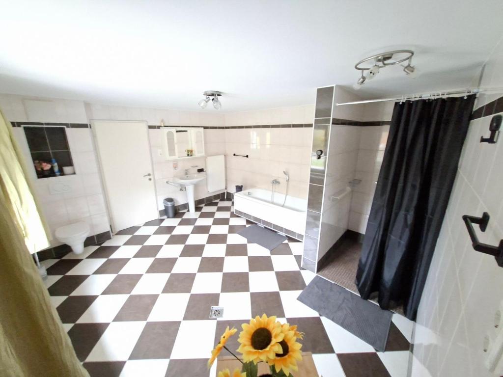 a bathroom with a checkered floor and a tub at Ferienwohnung am Nissberg Grünau im Almtal in Grünau im Almtal