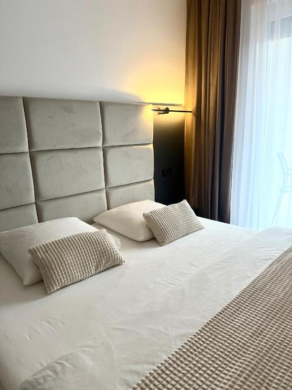 a large white bed with two pillows on it at Adora Park Exclusive Stay in Arad
