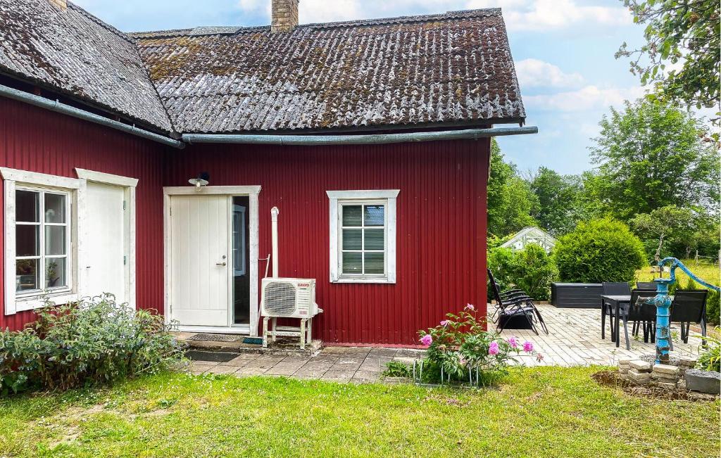 une maison rouge avec une porte blanche et une chaise dans l'établissement Holiday Home Tingstäte Martebo Kvie, à Tingstäde