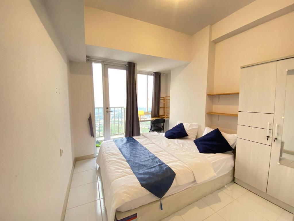 ein Schlafzimmer mit einem großen Bett mit blauen Kissen in der Unterkunft Tokyo River side PIK2 By Micky Studio 8 in Muara
